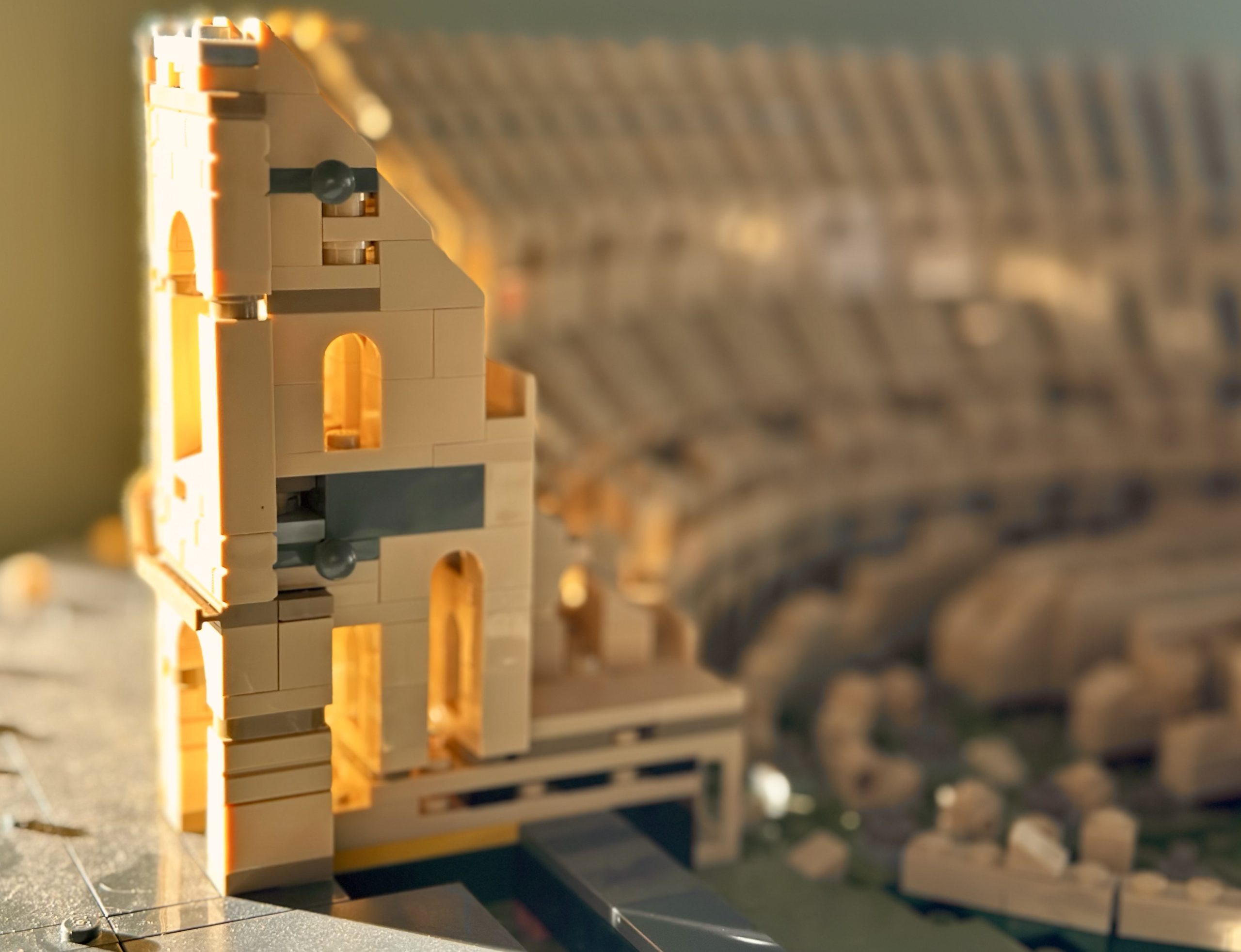 Golden hour sunlight hitting an unfinished LEGO model of the Colosseum.