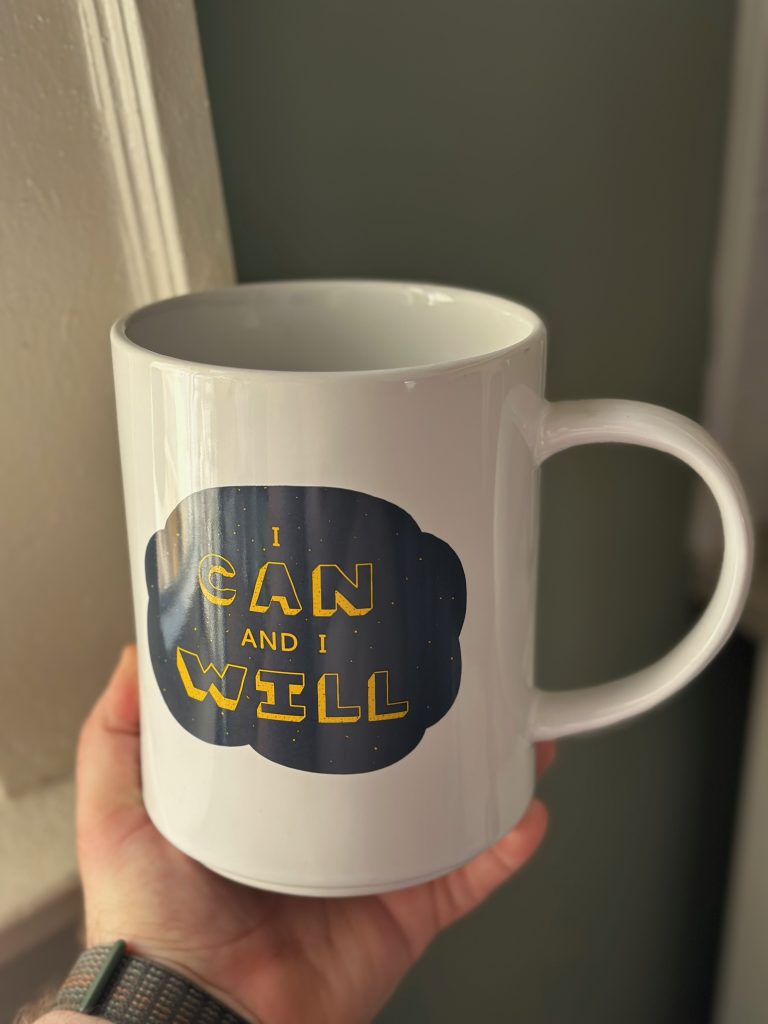 An absurdly large white mug with text that reads "I can and I will" on the side.